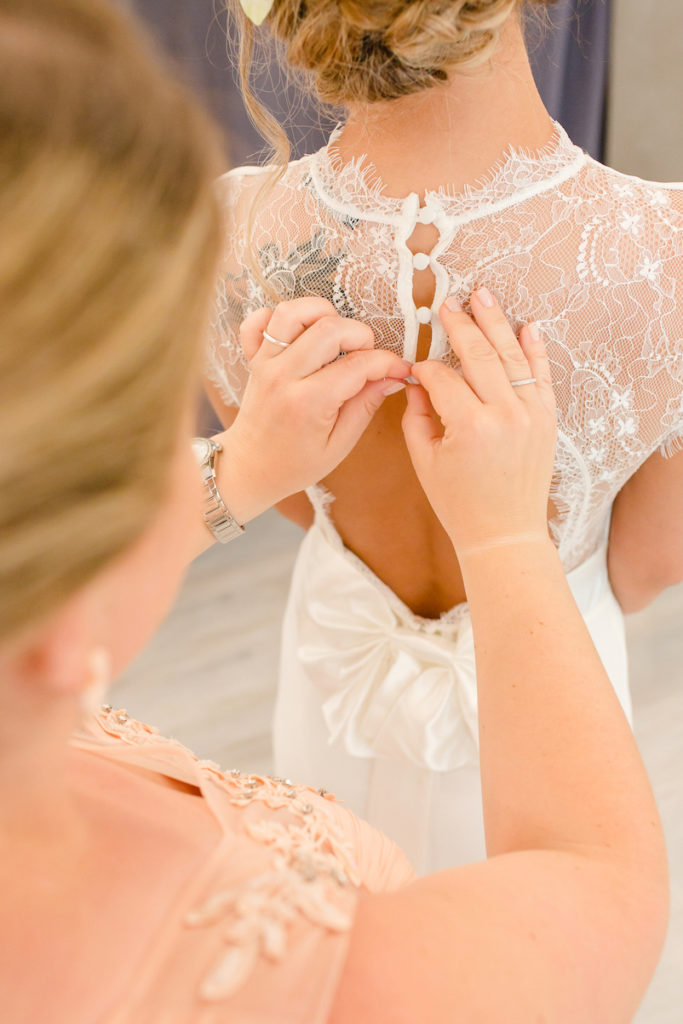 Brautjungfer hilft der Braut beim Brautkleid anziehen beim Getting Ready Shooting mit Fotograf Markus Winkelbauer